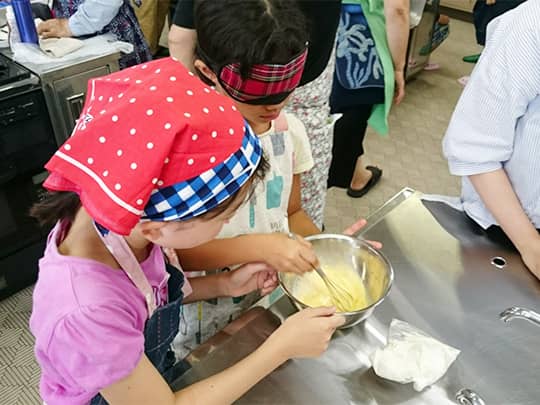 アイマスクを着用してホットケーキ作りをしている様子