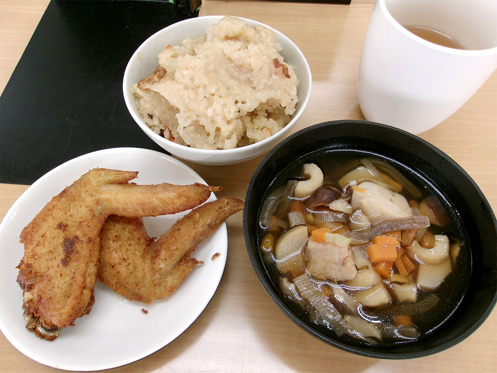 新潟の料理のっぺとカレー味の手羽先揚げと茶色い赤飯の写真