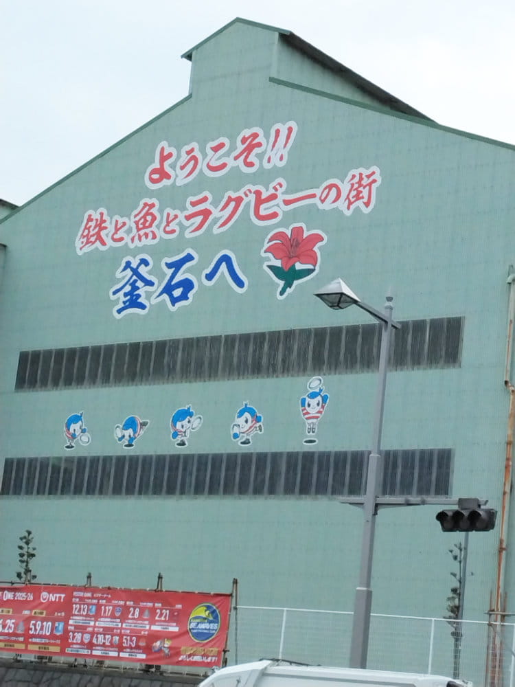 ようこそ!!鉄と魚とラグビーの街釜石へと書かれた建物の写真